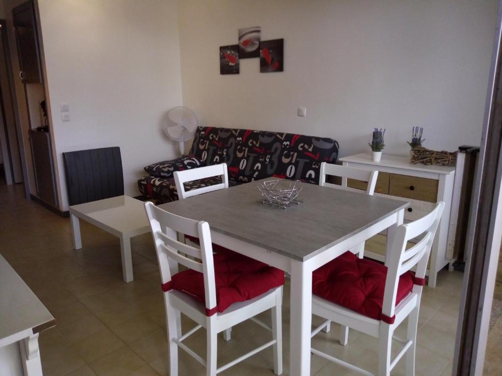 sala de estar con mesa, sillas y sofá en Les Residences Pinea, en Calvi