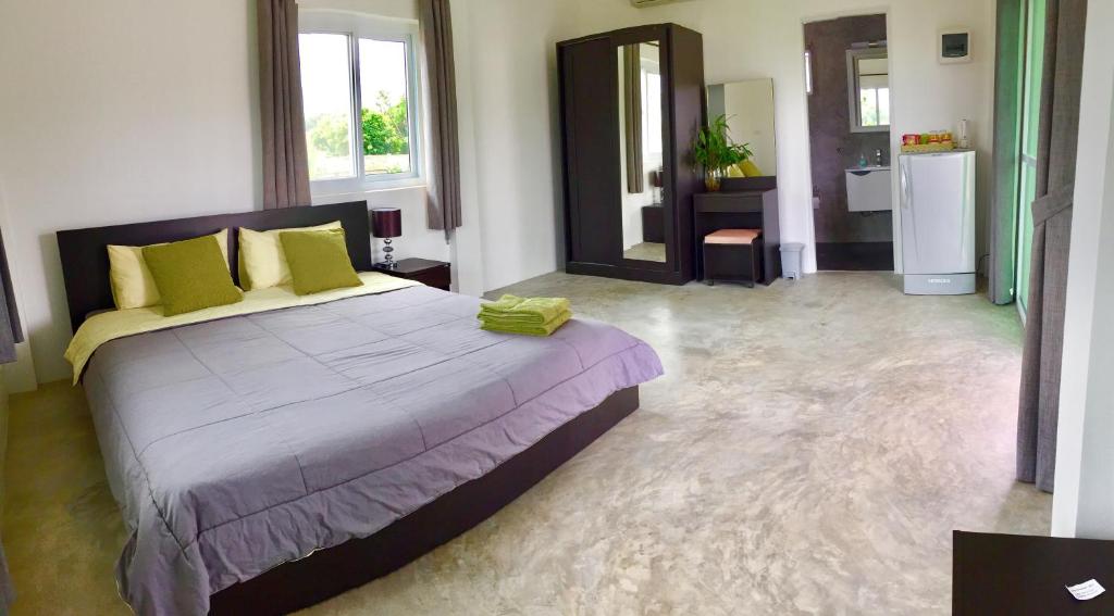 a bedroom with a large bed and a bathroom at Swiss Bungalow Cha Am in Cha Am