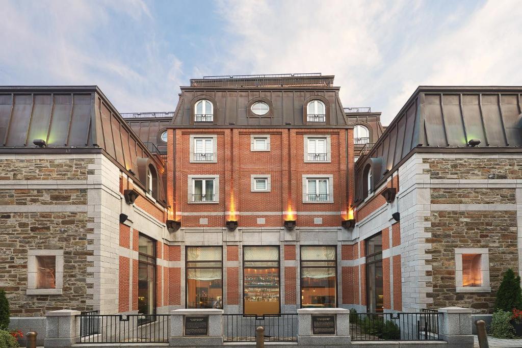 een groot bakstenen gebouw met een klok erop bij Auberge Saint-Antoine in Québec