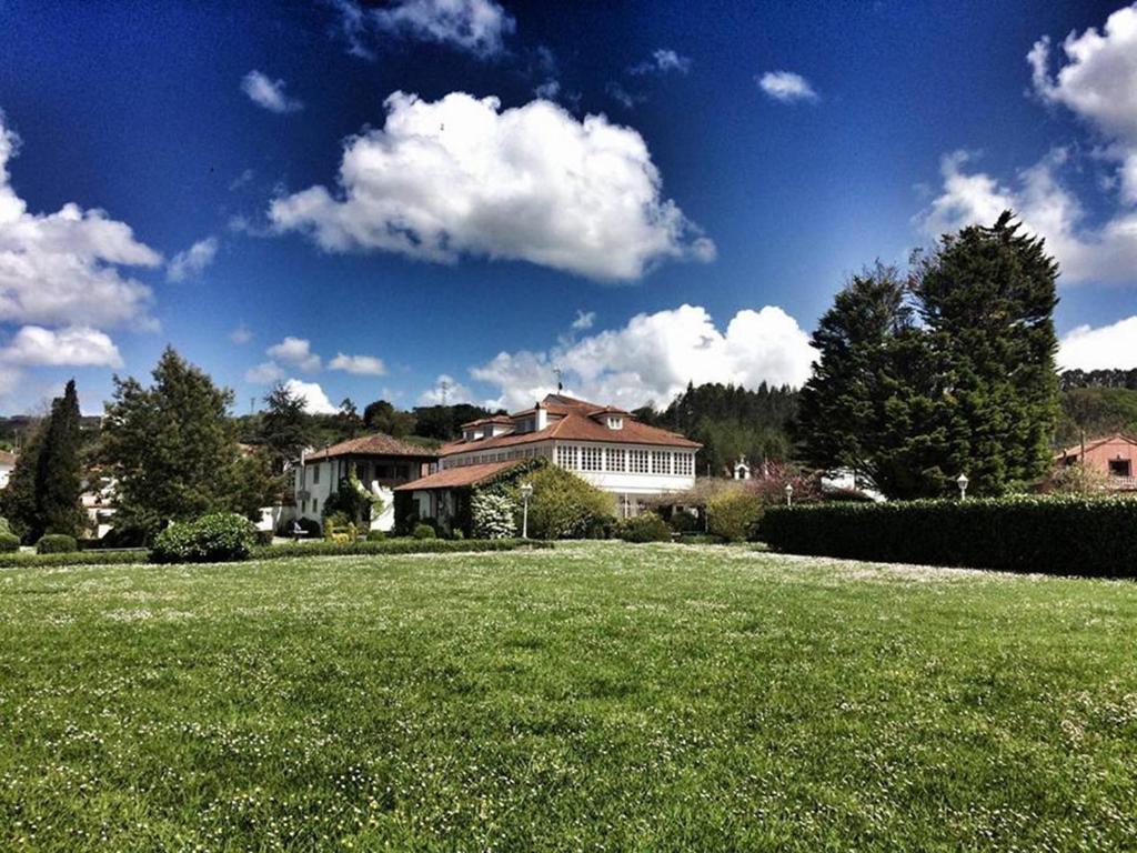 a house in a yard with a field of grass at La Casona de Amandi in Villaviciosa