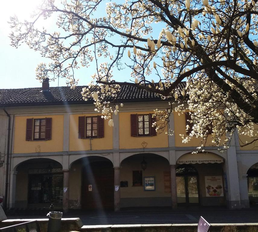 un edificio amarillo con flores blancas delante de él en casa zazalica, en Binasco