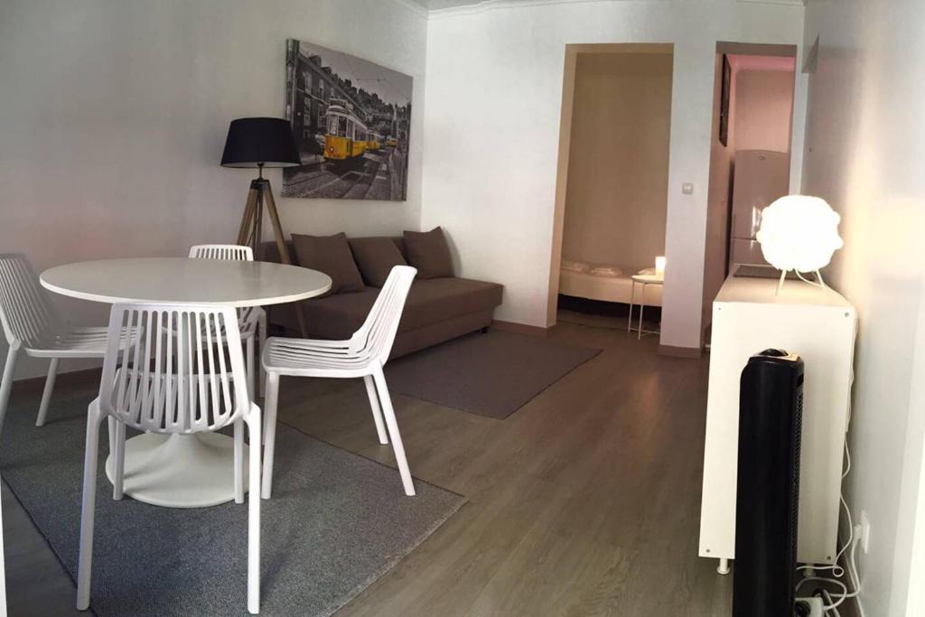 uma sala de estar com um sofá, uma mesa e cadeiras em New Luxury Apartment - Lisbon Center em Lisboa
