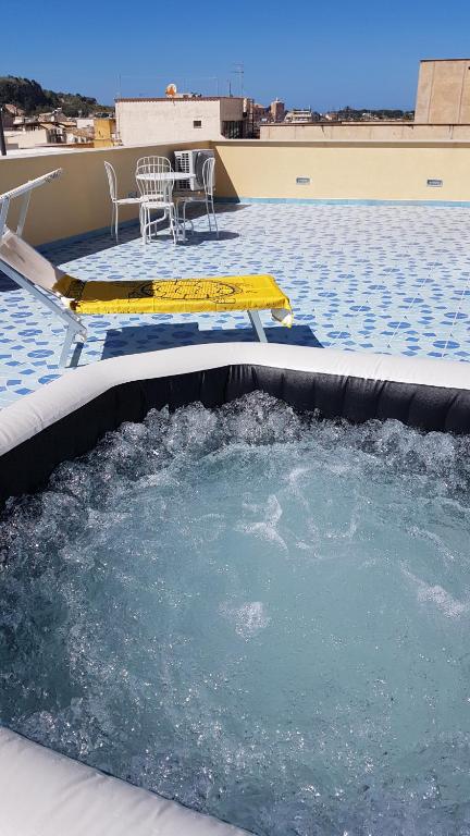 une piscine d'eau avec une table et une chaise dans l'établissement Residenza del Mare & SPA, à San Vito Lo Capo