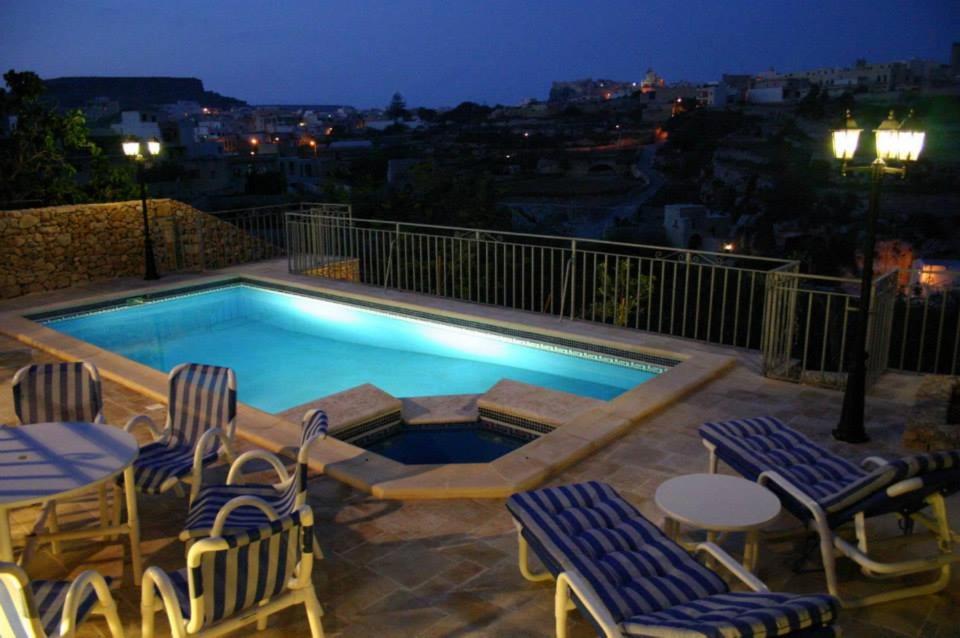 a swimming pool with some chairs and a table and a table and chairs at Sylvia' s Millhouse in Kerċem