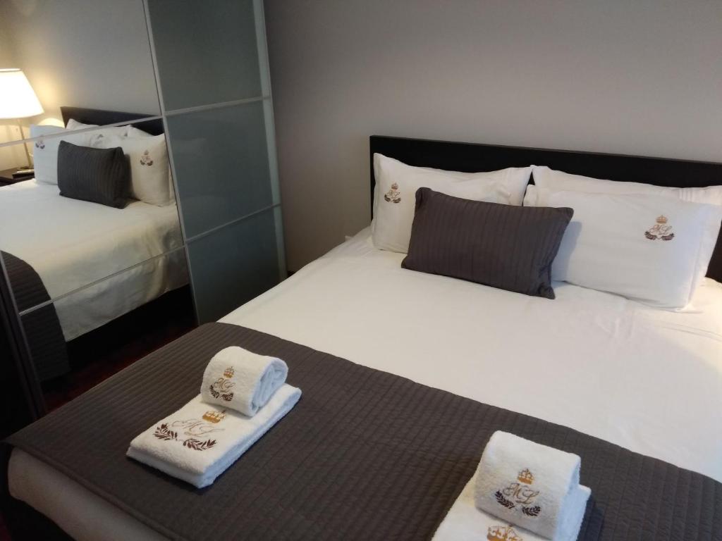 ein Hotelzimmer mit 2 Betten und Handtüchern darauf in der Unterkunft ML Apartments Almirante in Porto