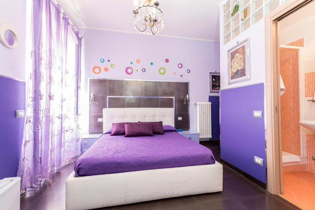 a purple bedroom with a large bed with purple sheets at Roma Gianicolense in Rome