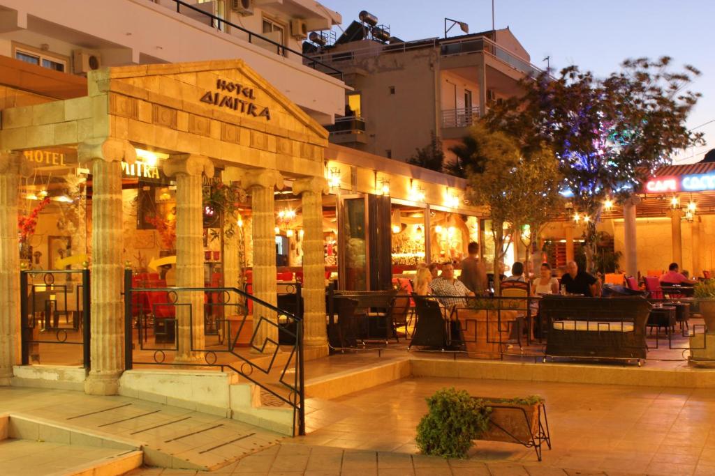 un restaurante con gente sentada fuera de él por la noche en Dimitra Hotel, en Faliraki