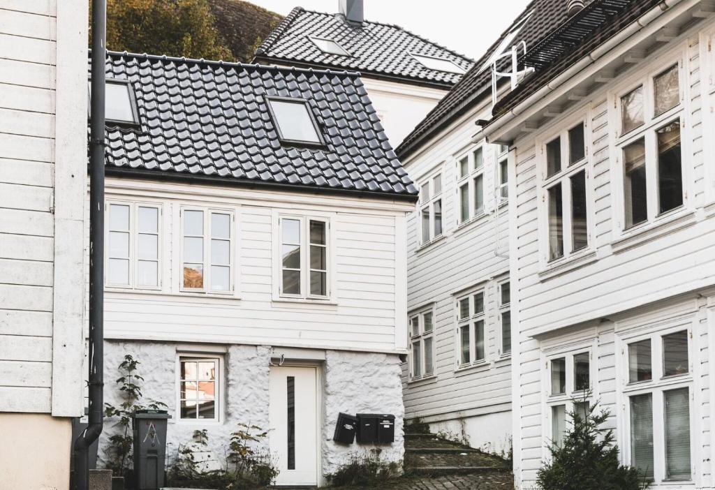 
a white building with a black roof and windows at Skuteviken Apartments 40 in Bergen
