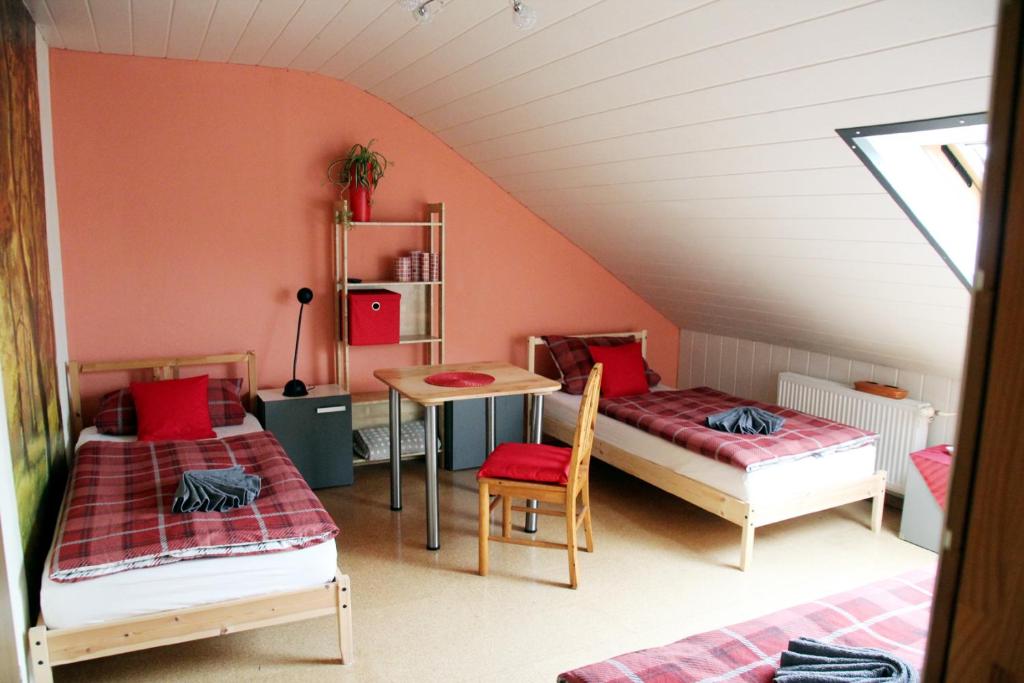 a attic room with two beds and a table at Monteurzimmer Beate Ackermann in Hochstadt am Main