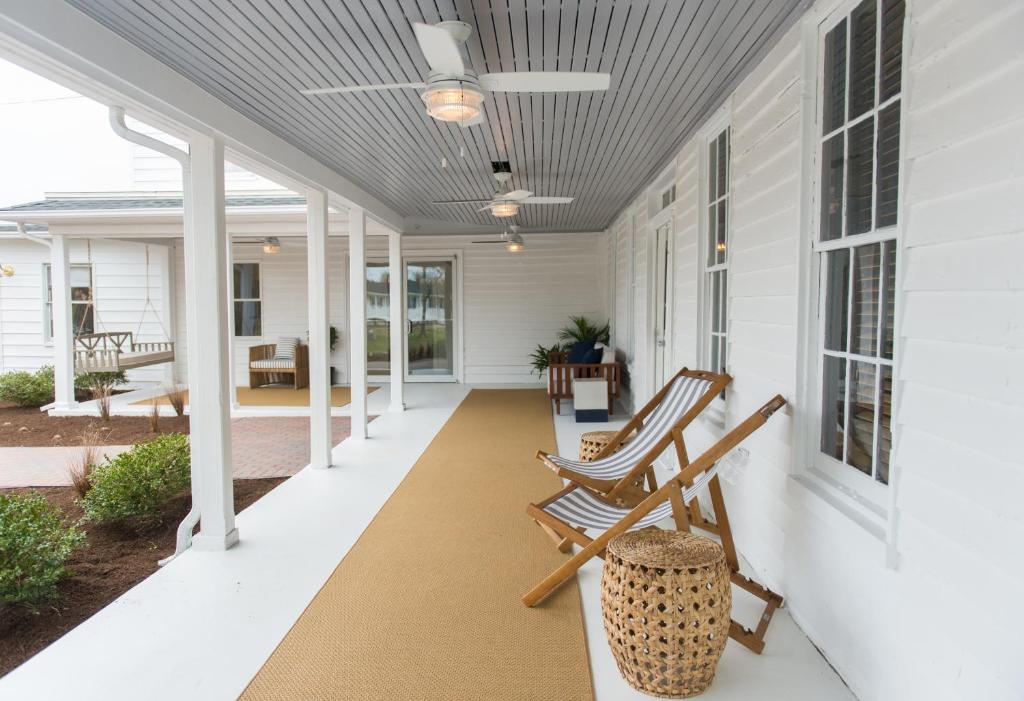 a porch with rocking chairs and a ceiling at Wylder Hotel - Tilghman Island in Saint Michaels