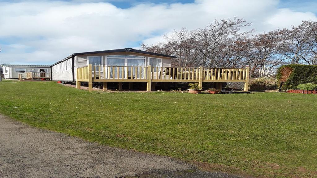 a tiny house on a deck in a yard at Caravan on Fantastic site in Dunbar