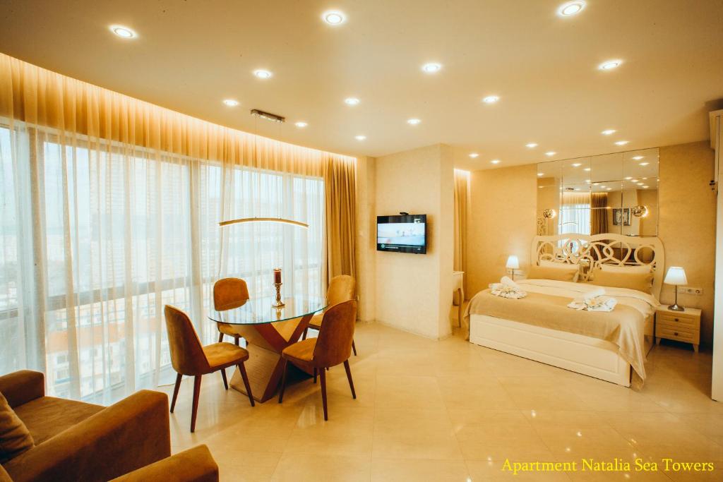 een slaapkamer met een bed en een tafel in een kamer bij Apartment Natalia Sea Towers in Batoemi