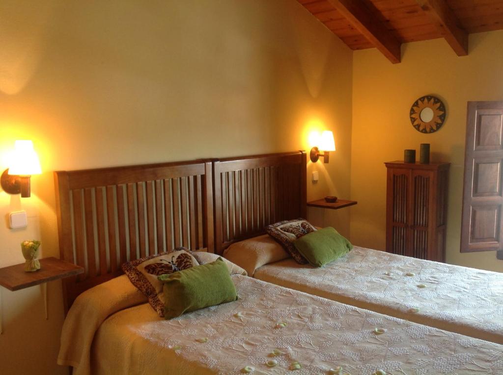 um quarto com duas camas e um relógio na parede em Las Casucas de Gema em Isla