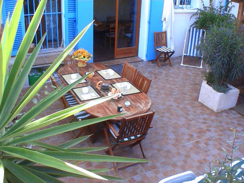 Une table et des chaises en bois sont disponibles sur la terrasse. dans l'établissement Les Chambres de Solliès, à Solliès-Pont