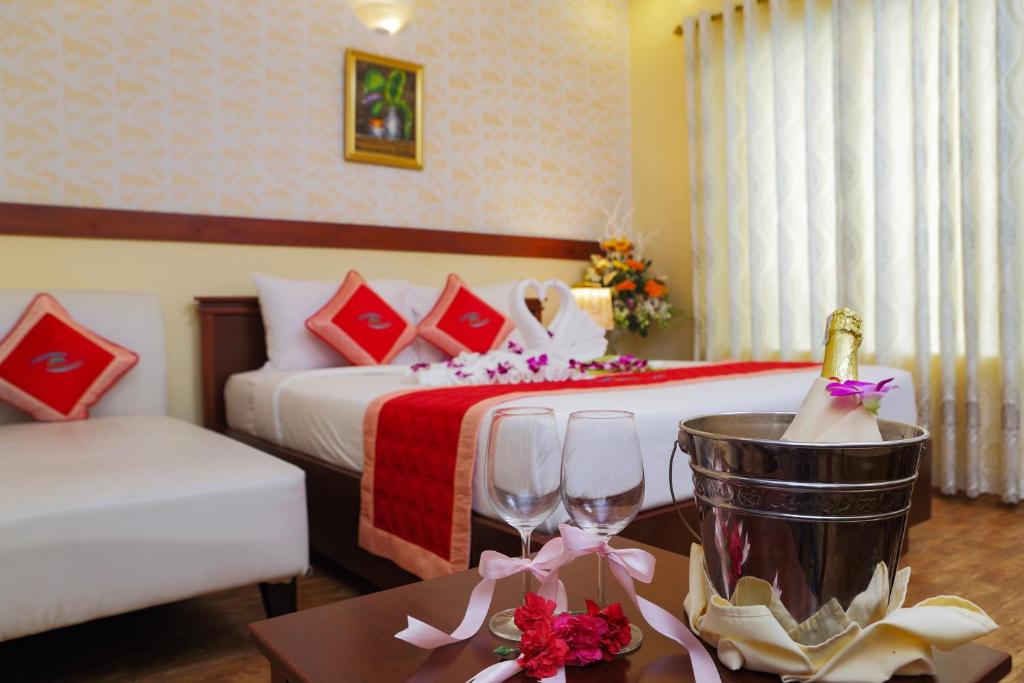 una camera d'albergo con letto e tavolo con bicchieri da vino di Kim Hoa Resort a Phu Quoc