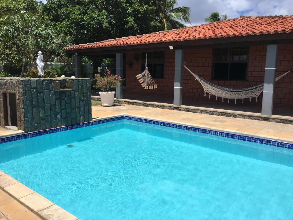 a swimming pool in front of a house at Itacimirim Beach House in Itacimirim