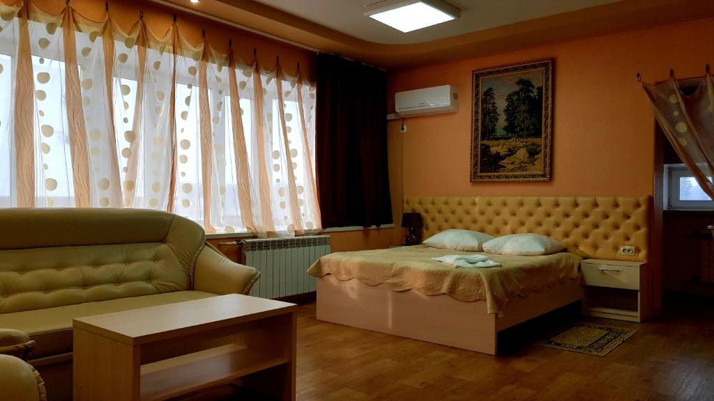 a small bedroom with a bed and a couch at Hotel Sozvezdie Medveditsy in Lesosibirsk