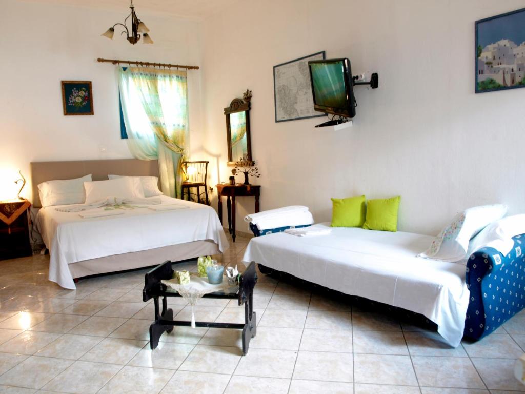 Livadi Astypalaias的住宿－梅勒尼奧公寓酒店，一间卧室设有两张床,墙上配有电视。