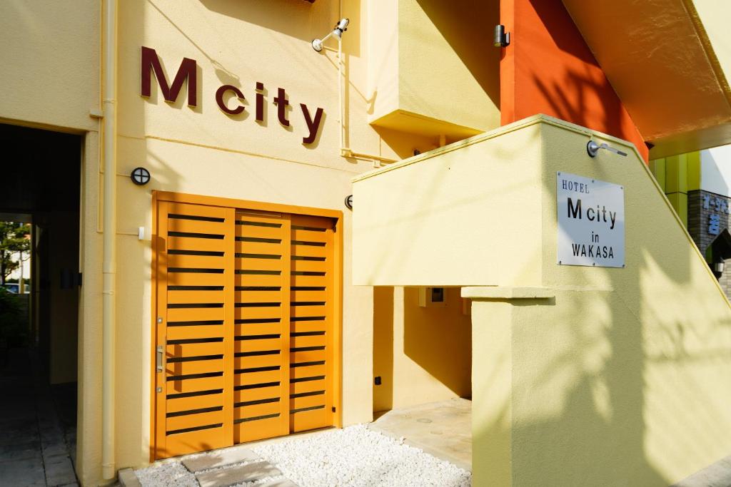 a sign on the side of a building with a garage at Mcity in Wakasa in Naha