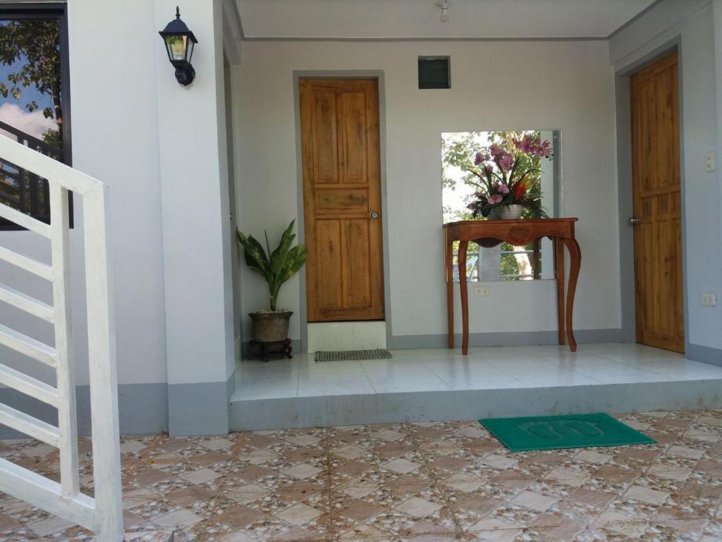 una habitación con una puerta y una mesa con un jarrón de flores en Villa Feliza, en Loboc