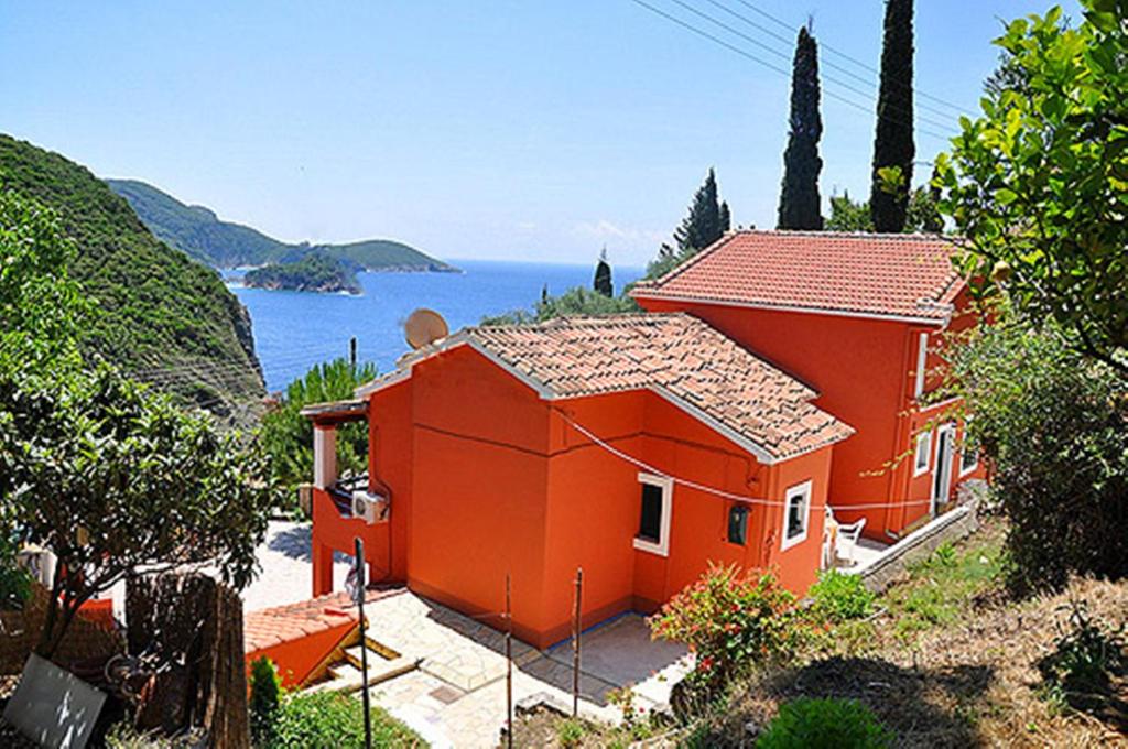 una casa arancione con vista sull'oceano di Kiki Apartments a Paleokastritsa
