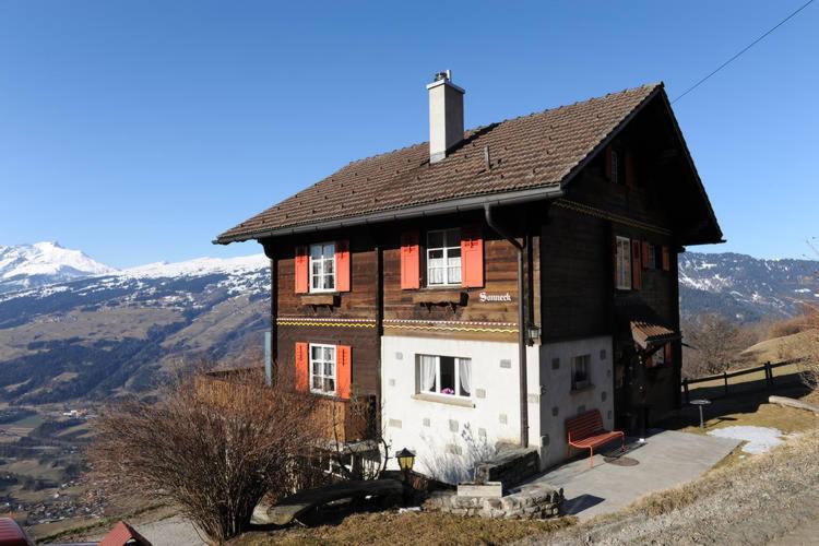 una casa en la cima de una colina con montañas en Attractive holiday home with a beautiful view en Trans