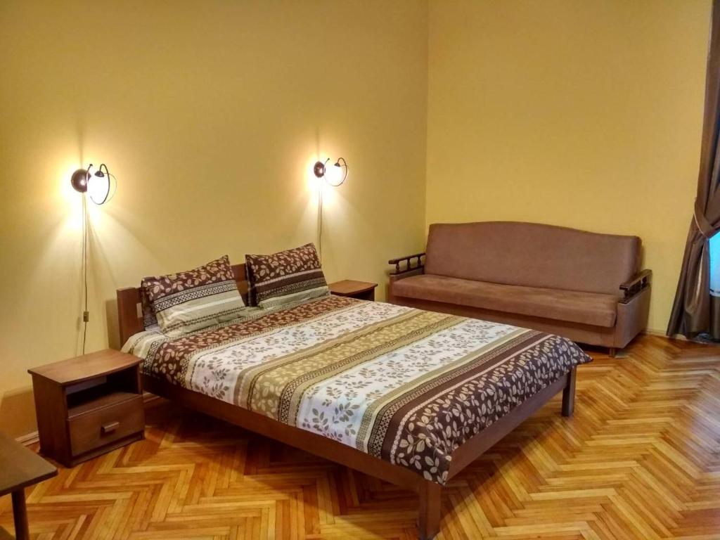 a bedroom with a bed and a couch at Apartment on Virmens'ka Street in Lviv