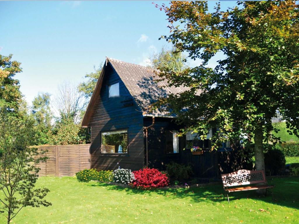 a blue house with a bench in a yard at Deichoase Piratenhaus in Friedrichskoog