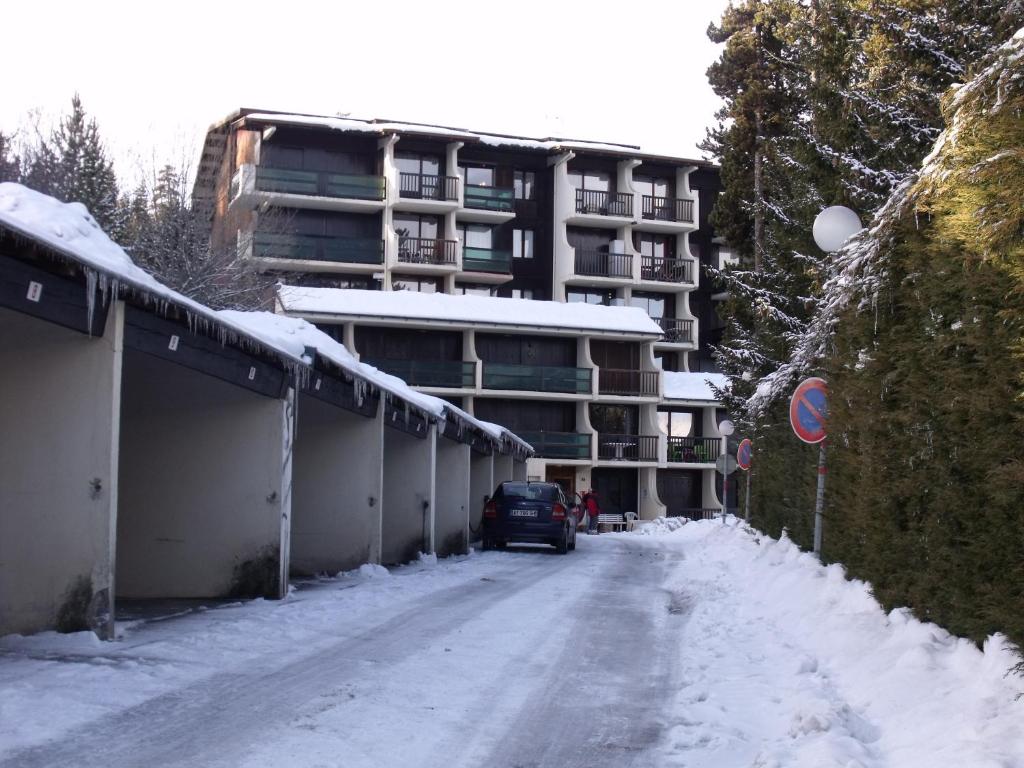 una calle cubierta de nieve frente a un edificio de apartamentos en Appartement Val Cristal, en Font-Romeu