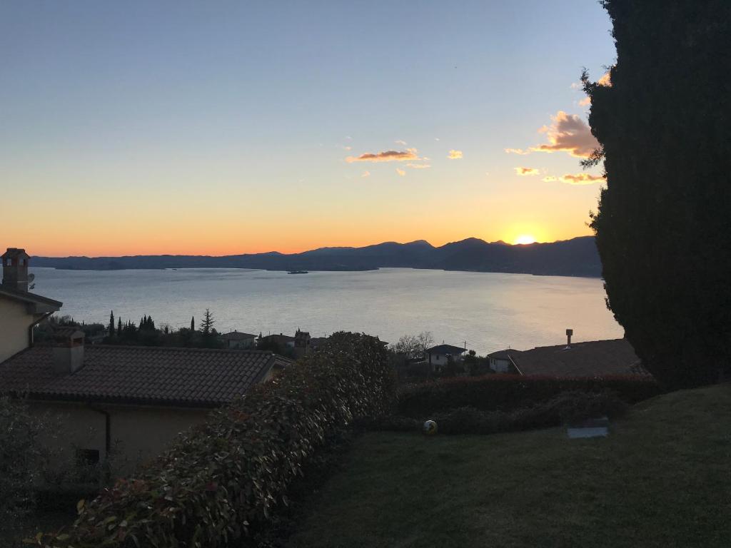 een uitzicht op de oceaan bij zonsondergang vanuit een huis bij Appartamento Lago di Garda Albisano in Torri del Benaco