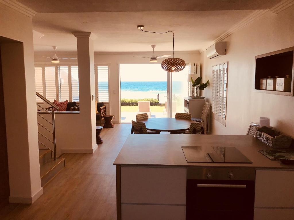 uma cozinha e sala de estar com vista para o oceano em Luxury Beach Villa (On the Beach) em Ballito