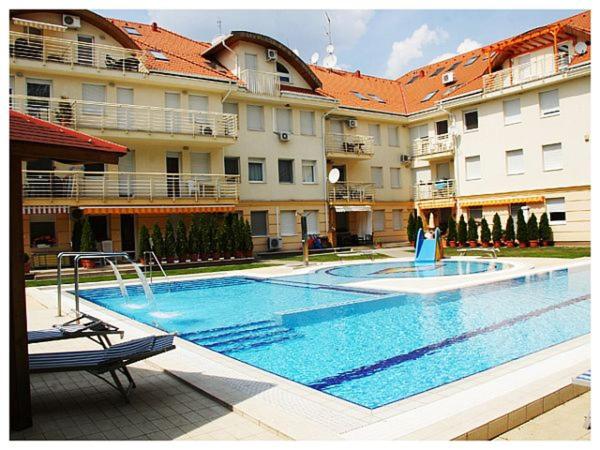 una gran piscina frente a un edificio en Family Wellness Apartman en Hajdúszoboszló