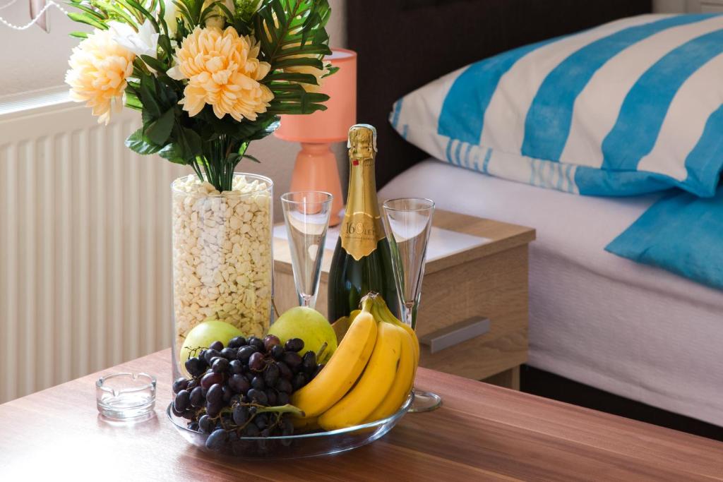 uma mesa com uma taça de fruta e um vaso com flores em Guesthouse Vila Puzic em Banja Luka