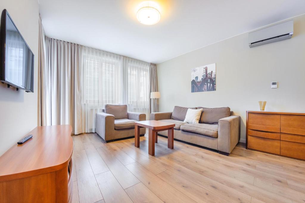 a living room with a couch and a table at Apartament Sun & Snow Gwiazda Morza in Władysławowo