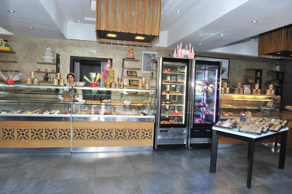 a woman standing behind a counter in a bakery at Studiotel Afoud in Agadir