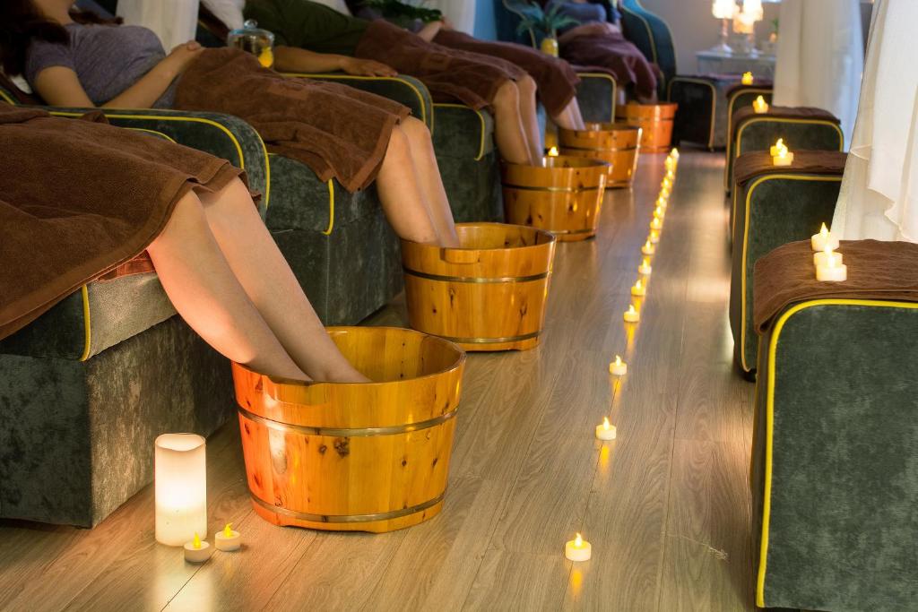 a group of people sitting in buckets with candles at Happy Day Riverside Hotel & Spa Danang by Haviland in Danang