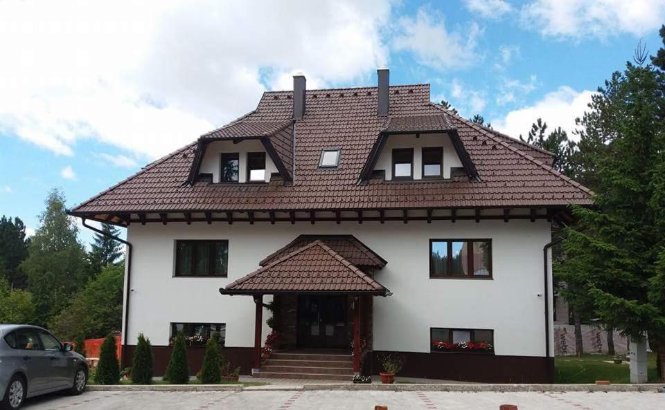 a large white house with a brown roof at LuFi Penthouse Apartment in Zlatibor