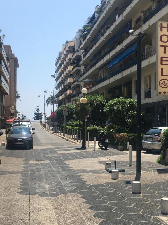 uma rua com carros estacionados ao lado de um edifício em Studio carré d'or situé à 50 m de la plage em Nice