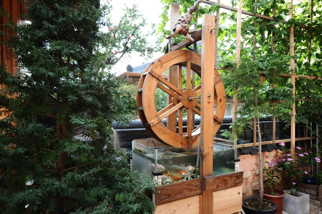een groot houten wiel in een tuin met planten bij Starlight Rest Area in Jeonju