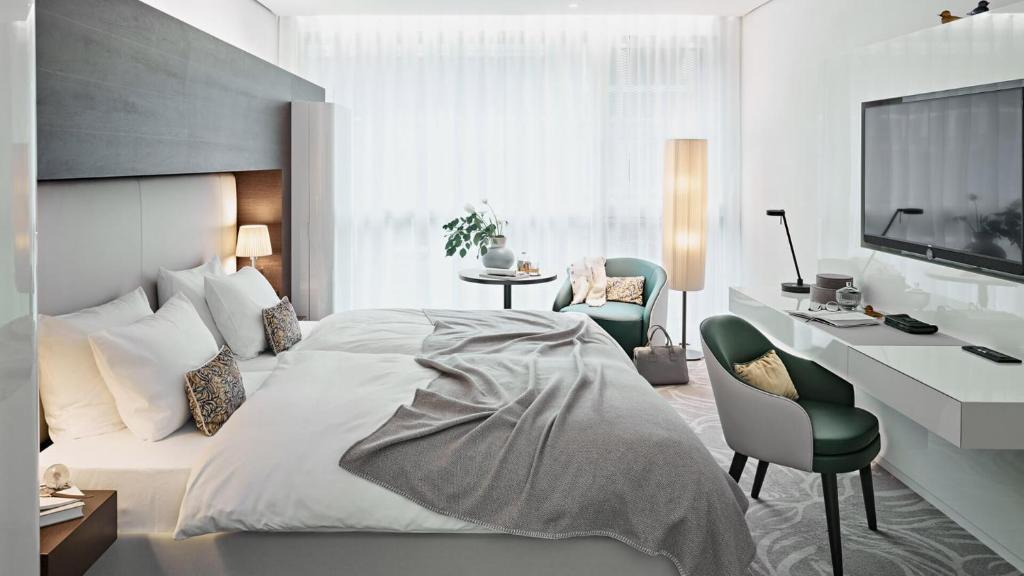 a bedroom with a bed and a desk and a television at SIDE, Hamburg, a Member of Design Hotels in Hamburg