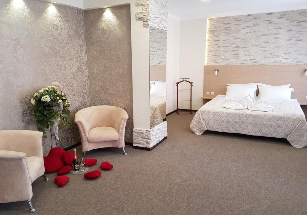 Habitación de hotel con cama y rosas en el suelo en Vizit Hotel, en Perm