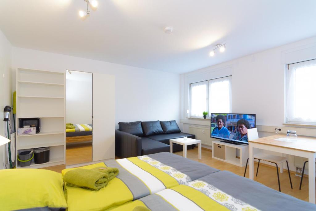 1 dormitorio con cama, sofá y TV en Private rooms next to subway en Núremberg