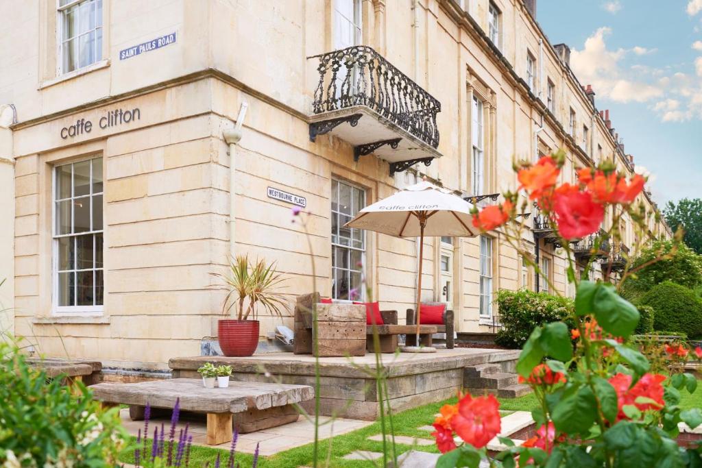 a building with a table and an umbrella in front of it at The Clifton Hotel Bristol in Bristol