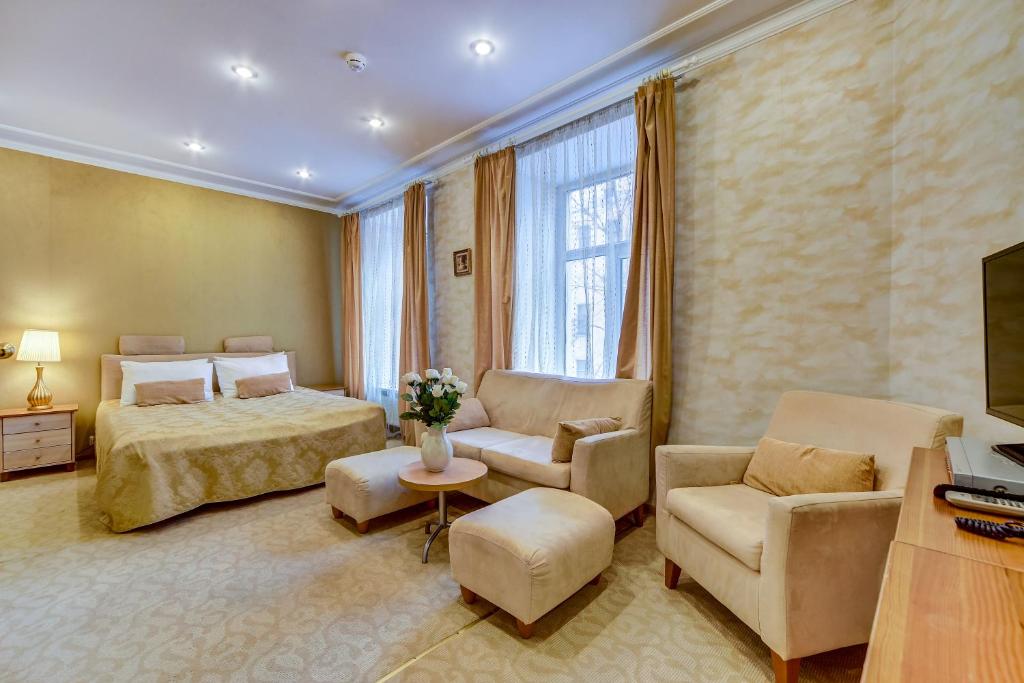 a hotel room with a bed and chairs and a television at Polikoff in Saint Petersburg