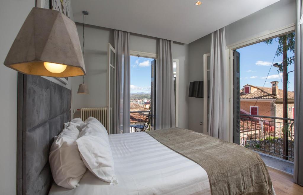 a bedroom with a large bed and a large window at Leto Nuevo Hotel in Nafplio