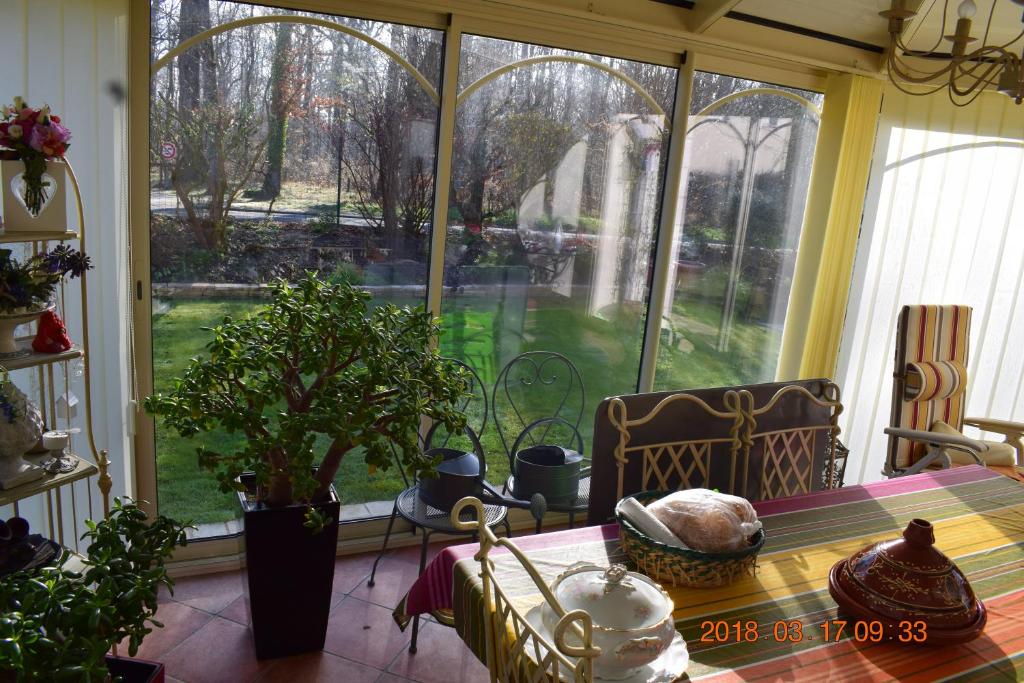 a dining room with a table and a large window at Les Tilleuls in Ballan-Miré