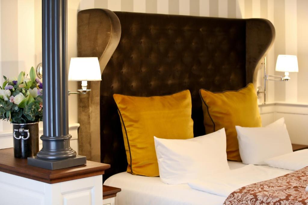 a hotel room with a bed with yellow pillows at Europa Hotel Kühlungsborn in Kühlungsborn
