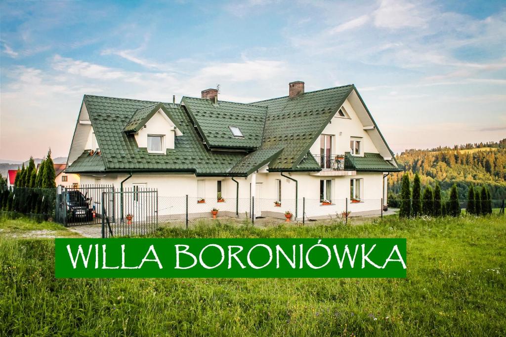 a white house with a green roof on a field at WILLA BORONIÓWKA Falsztyn nad Jeziorem Czorsztyńskim in Falsztyn