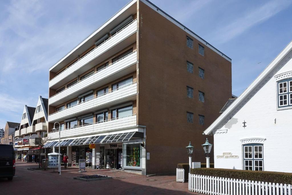 ein großes Backsteingebäude neben einem weißen Gebäude in der Unterkunft Appartment Nordlicht in Westerland