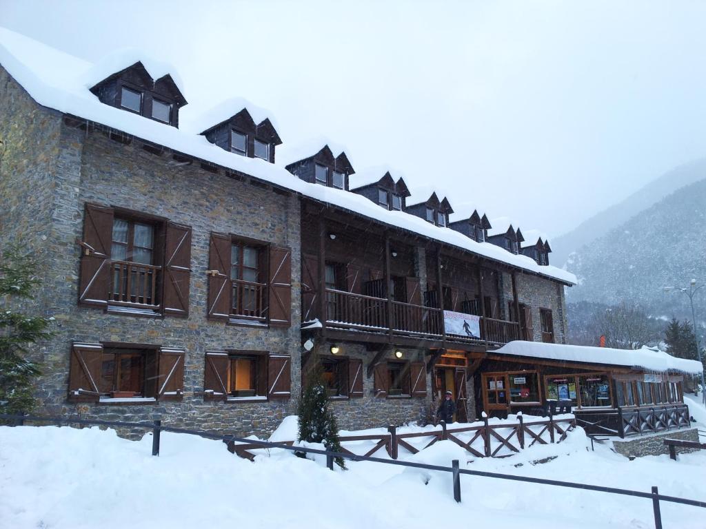 un gran edificio con nieve en el techo en Alberg Les Daines, en Espot